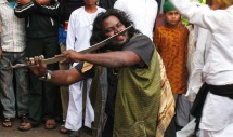 Title: Malang (Muslim ascetic) performing power; Rajasthan, India, November 2010 Caption: A troop of performing ascetics were a featured attraction at the annual death anniversary celebration ('urs) for Gaji Pir, a saint whose tomb is on a hill overlooking the town of Jahazpur, Rajasthan, India. Young men watch with mixed reactions. Older spectators advised me to feel no alarm, assuring me that the malang were merely wielding the magical power of illusion and not actually harming themselves.  