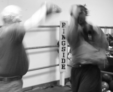 Trainer holding punching mitts for boxer