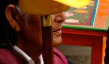 Title: Continuing prayer wheel (2011, Qinghai TAP, China) Caption: Old Tibetan women do not have to do any labor work. Grandmother was sitting in the corner of the house, with a prayer wheel. Other people were busy with cooking, cleaning, and all kinds of preparation for hosting a lunch with the living buddha. "The continuing prayer wheel is her blessing to us. Her serenity keeps everything in order."  