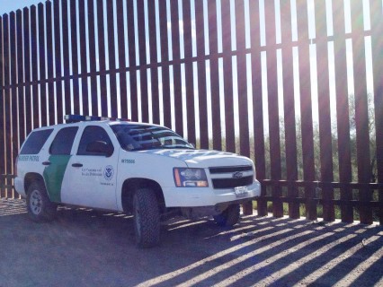 Border agent and wall. Photo courtesy Maia Wikler