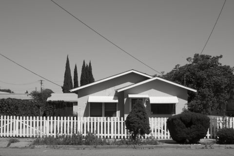 House behind a white-picket fence.