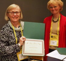 Photo of Katherine Verdery and Helena Wulff holding the Victor Turner Prize. Verdery holds the award in her hand.