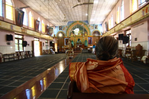 The sanctuary is empty, but for this woman sitting in one of the few pews in the wide open room.