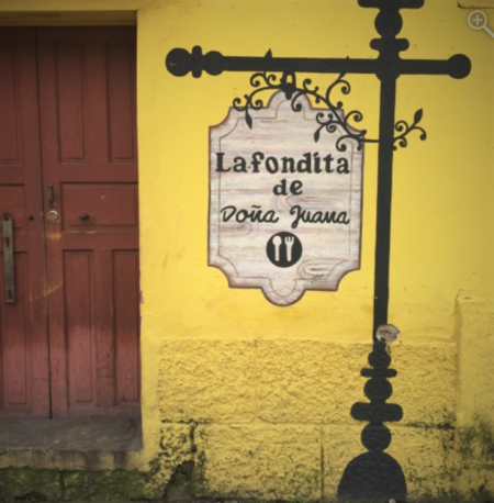 A painted sign on a yellow façade