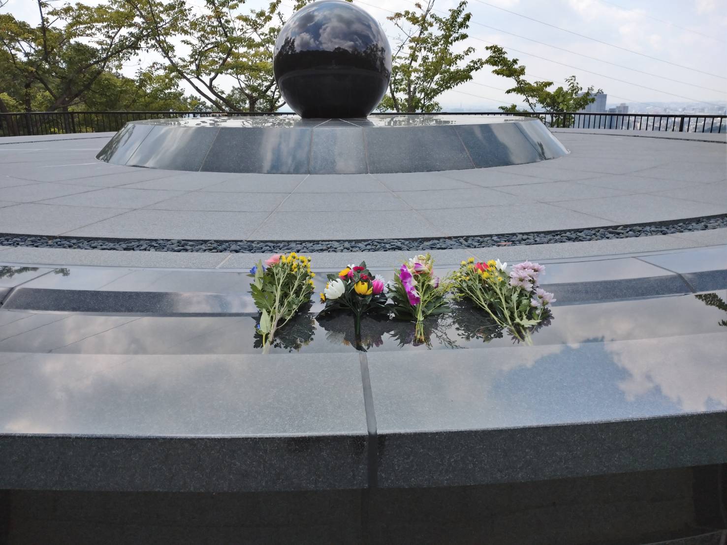 Photograph of flowers placed on a monument.