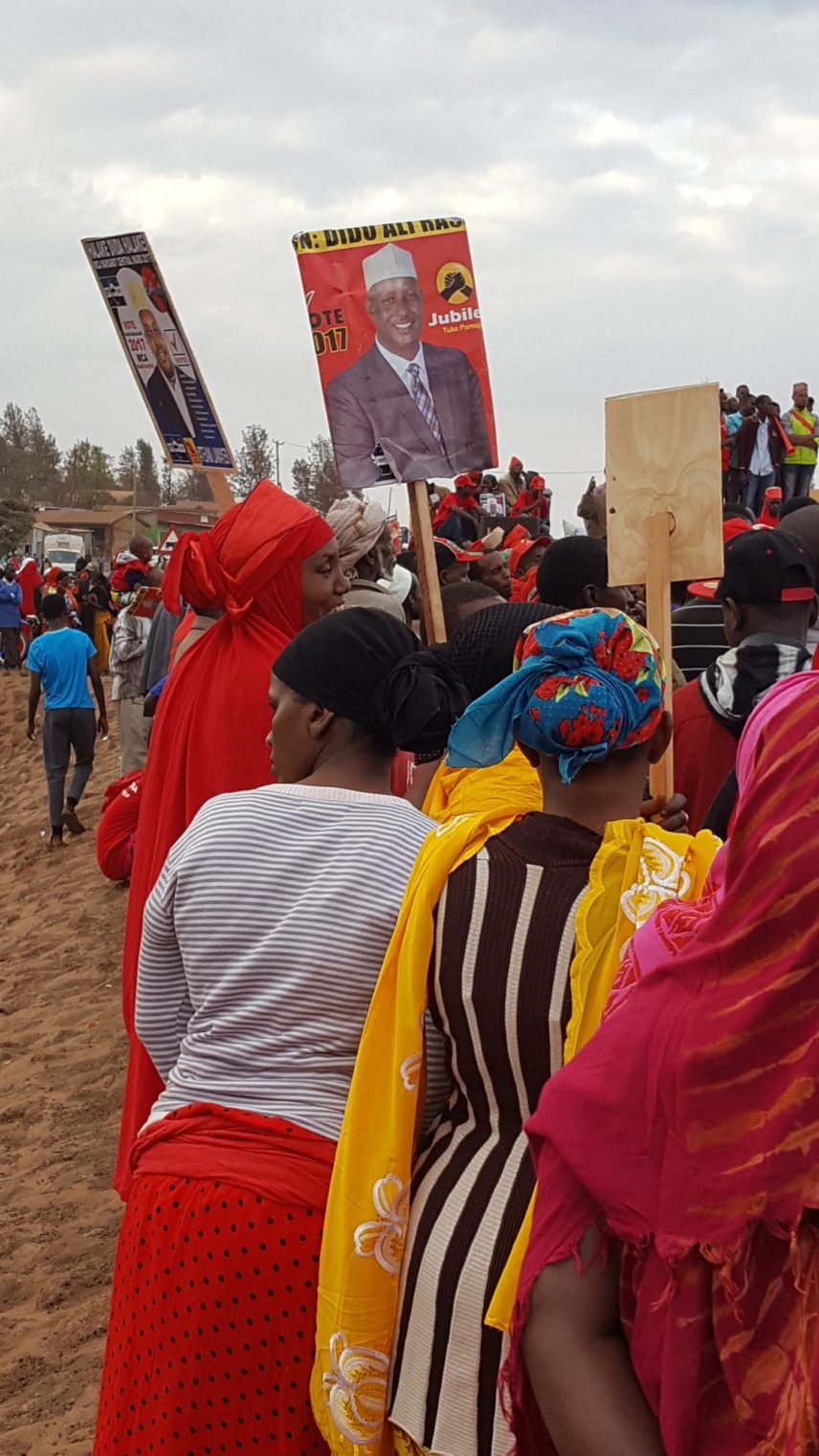 Photograph of a crowd holding signs.