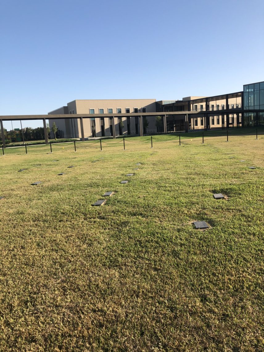 Photograph of a cemetery with a building in the background