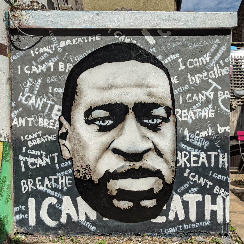 Photograph of a wall mural featuring the face of George Floyd