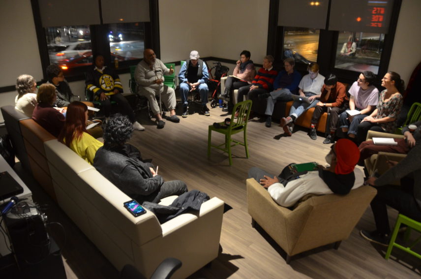 Photograph of people sitting in chairs arranged in a circle.