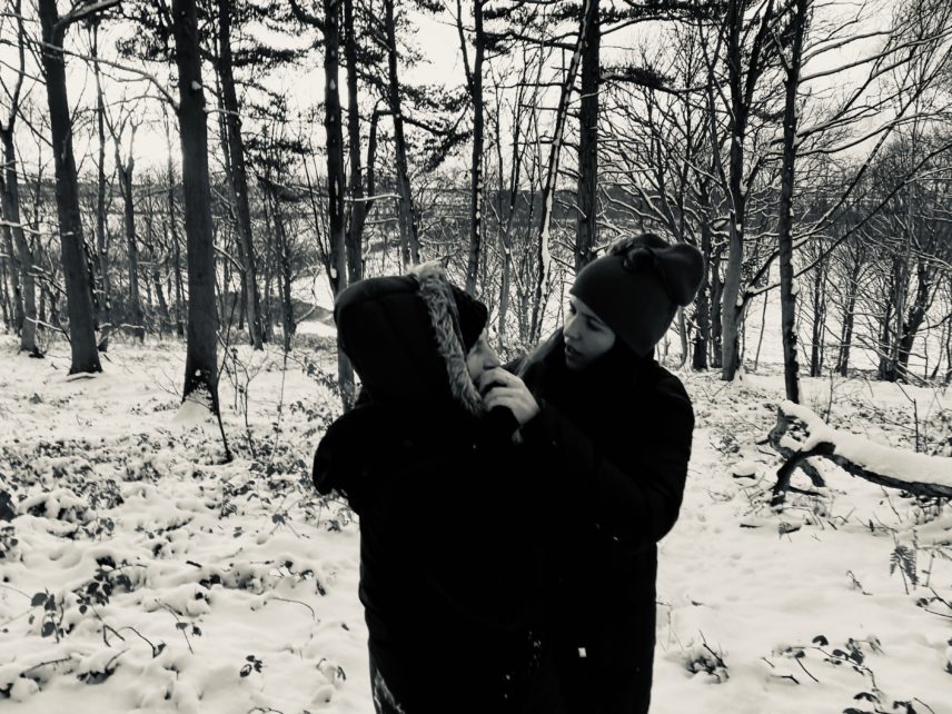 Black and white photograph of two people outdoors during winter