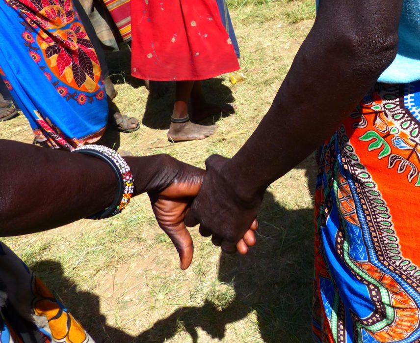 Photograph of two people holding hands outdoors