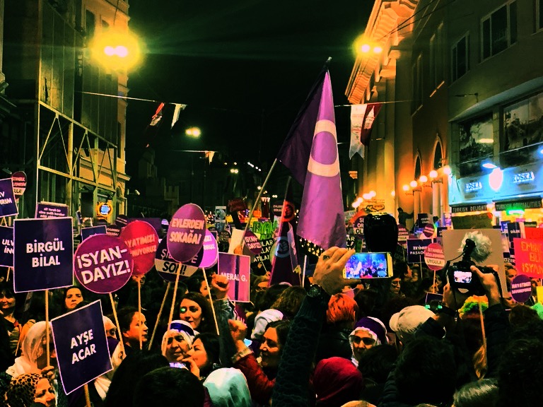 Women holding purple signs.