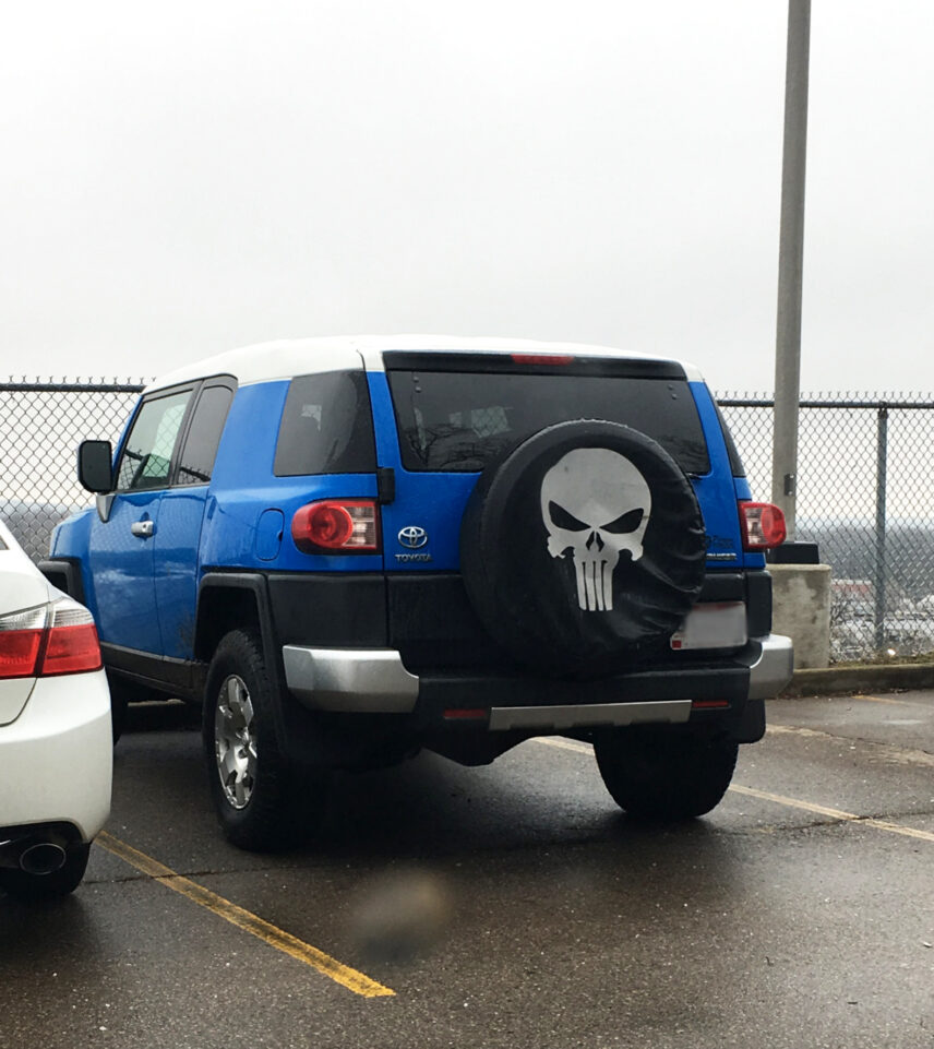 A photo of an S.U.V. with a skull printed on the tire cover.