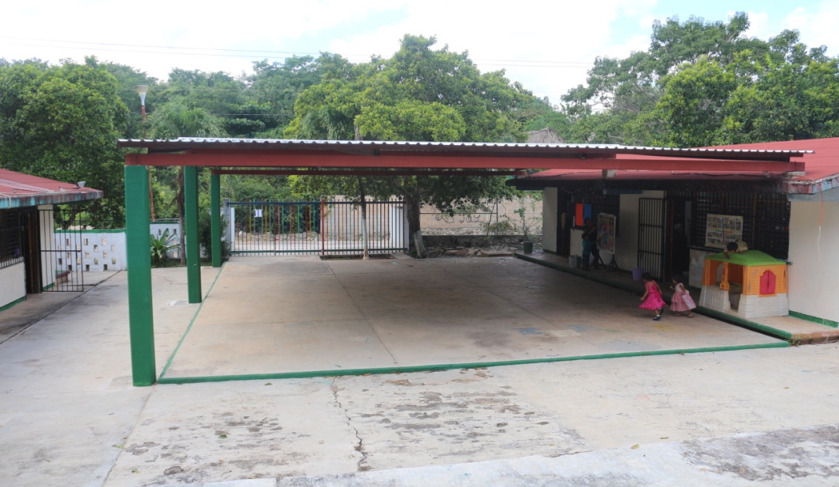 A photograph showing a one-level building with a metal dome besides it that covers a patio.