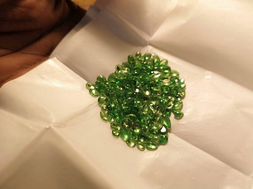 Photograph of green gems on white paper