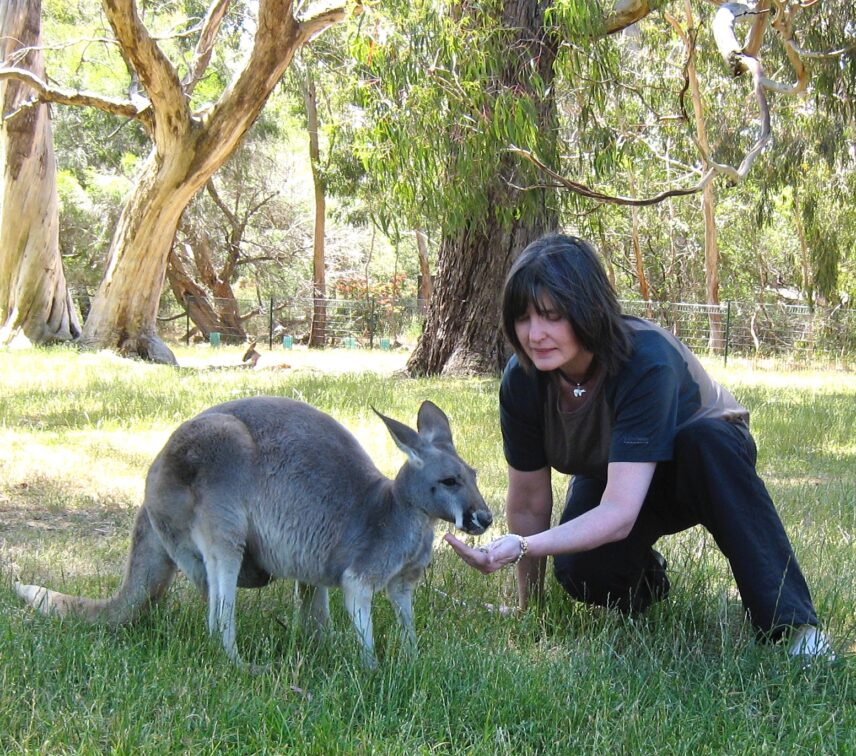 Photograph of a woman and kangaroo outdoors