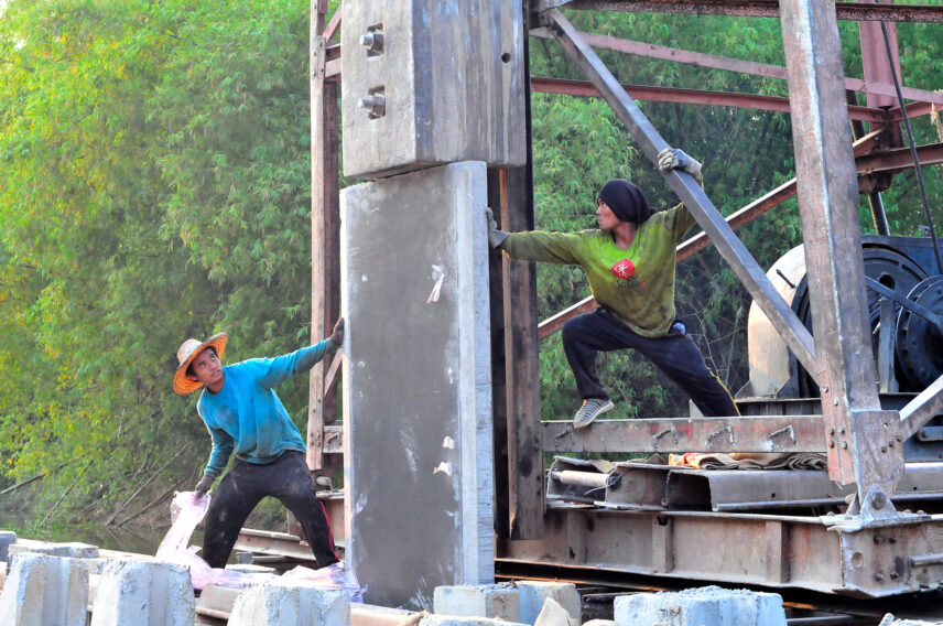 Photograph of two people on a river in the midst of construction
