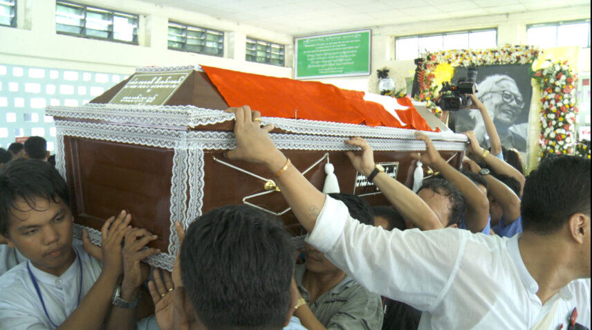 Photograph of people carrying a casket