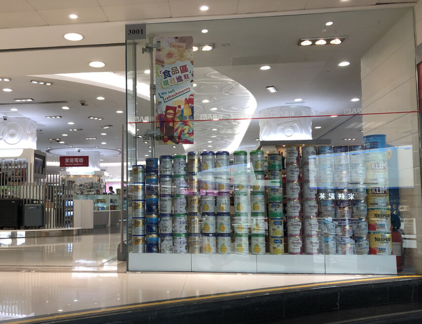 A shop window filled with cans of baby milk powder.