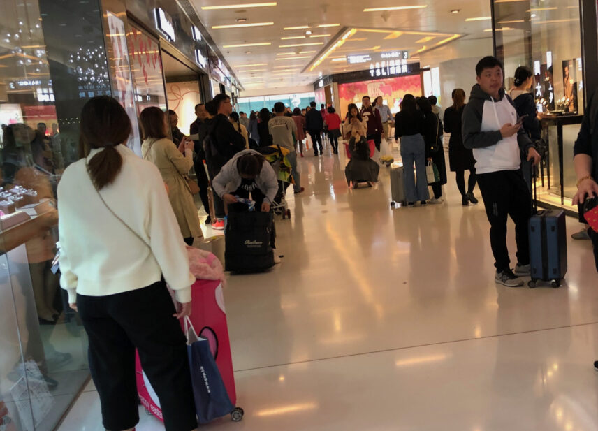 A picture of a crowded hallway outside of a local Hong Kong drugstore.