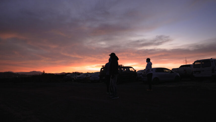 Photograph of a sunrise over parked cars