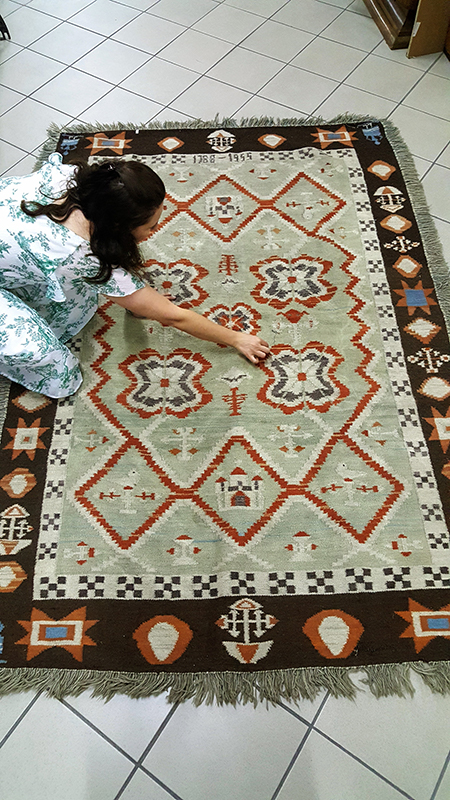 Woman kneeling in front of a carpet