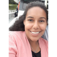Photograph of a woman with dark curly hair smiling