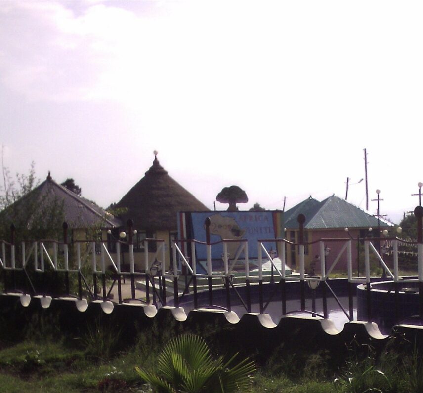 Photograph of a group of houses and a sign that reads "Africa Unite."