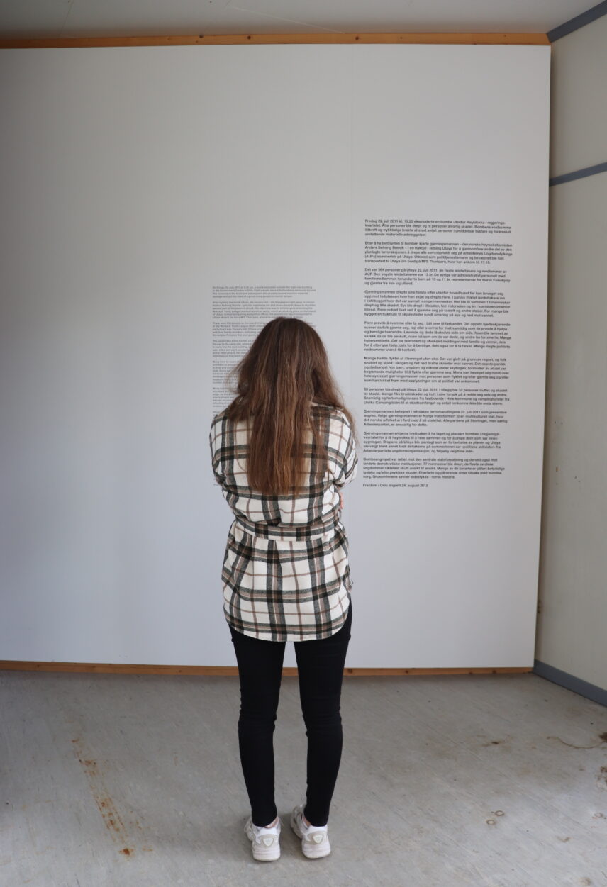 Photograph of a student reading signage in Utøya’s memorial exhibition.