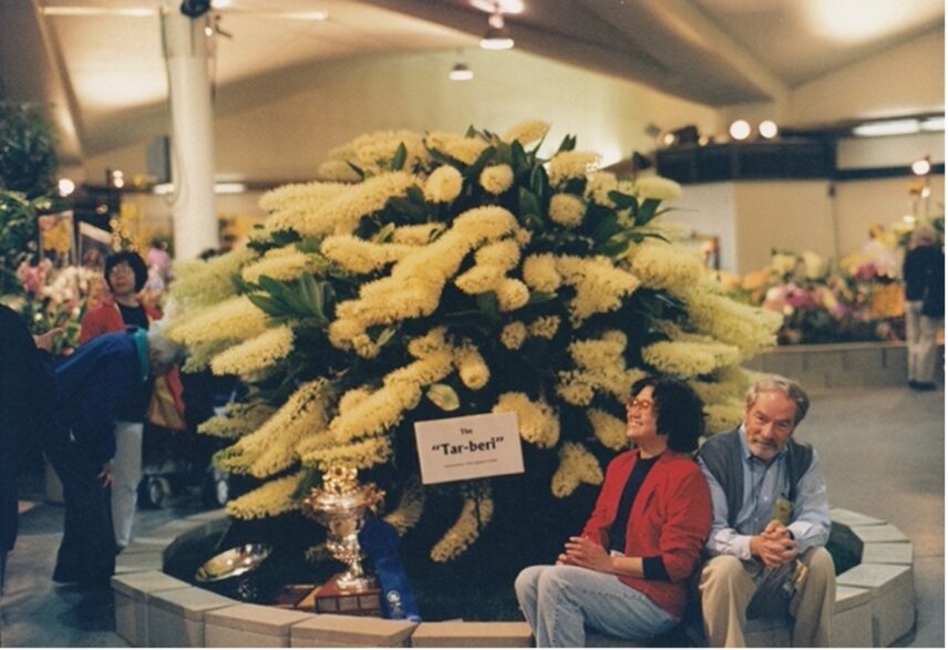 Donald Brown and Carrie Chu seated next to the world's largest orchid.