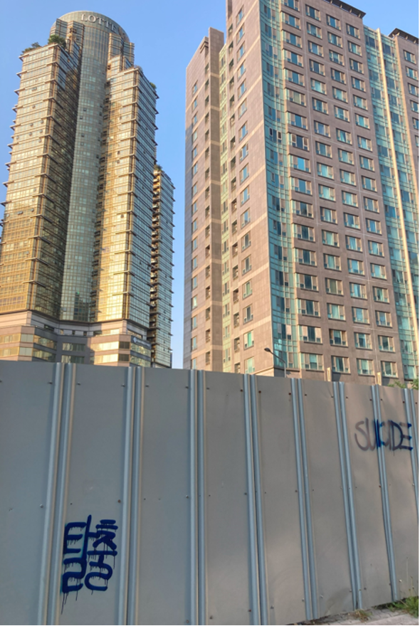 Alt text: Photograph of a construction wall with the words “Talchul" (escape, in Korean) and “Suicide” (in English).