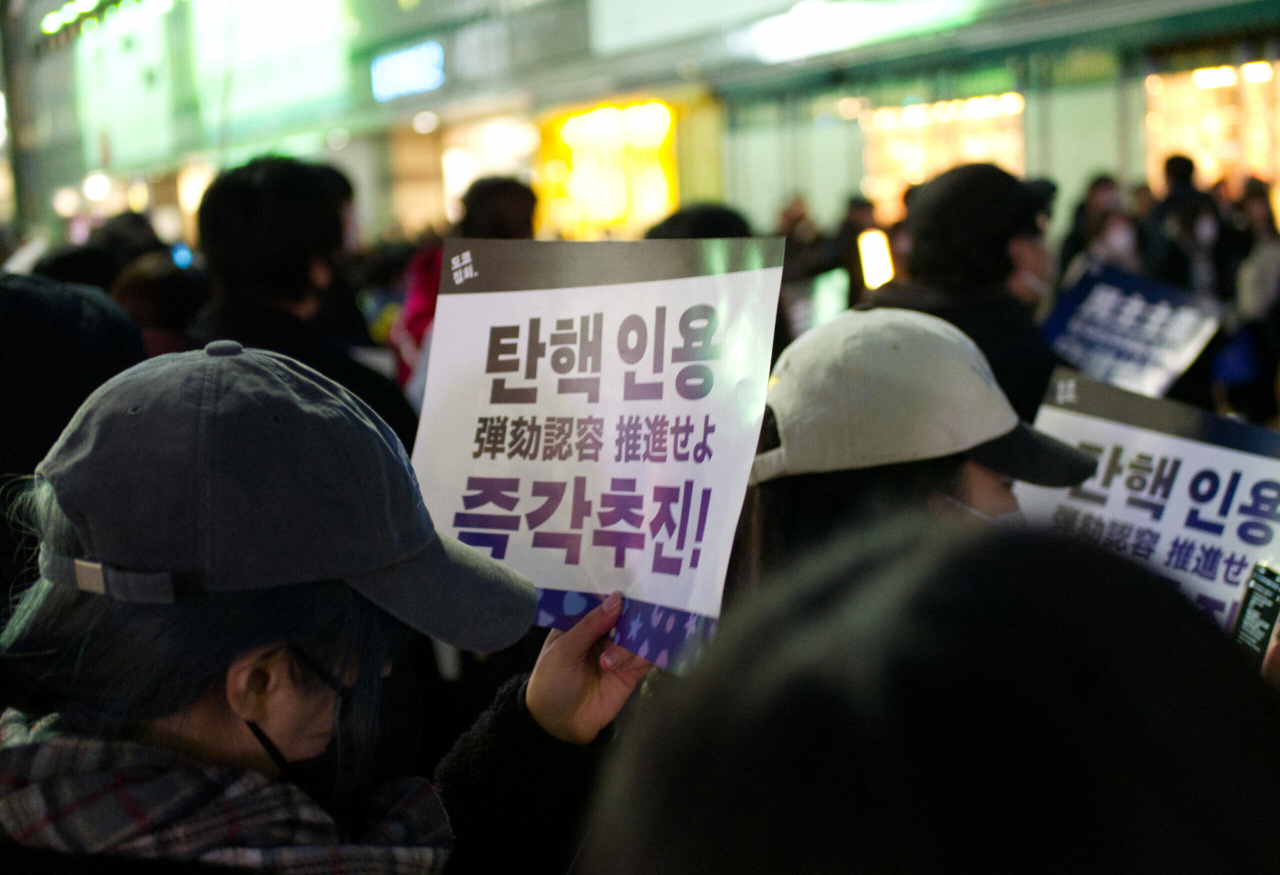 Protesters gathered at Shinjuku in Tokyo, Japan, on Jan 18, 2025. They carry signs reading “Immediately pursue impeachment” in both Korean (탄핵 인용 즉각추진) and Japanese (弾劾認容推進せよ).