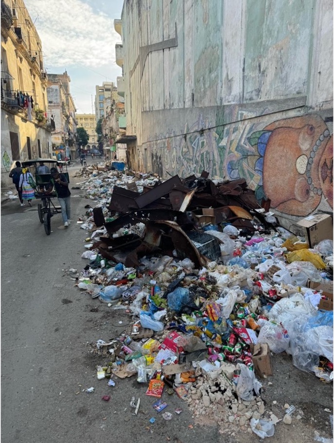 Trash piled by wall on street