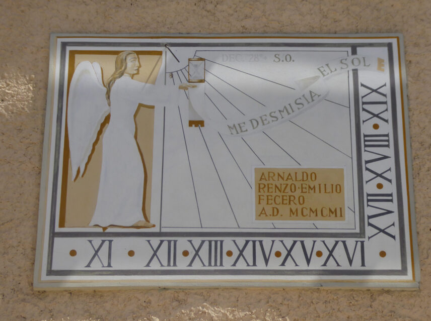 A ceramic sundial with a painted figure of an angel and roman numerals along the bottom and right edge