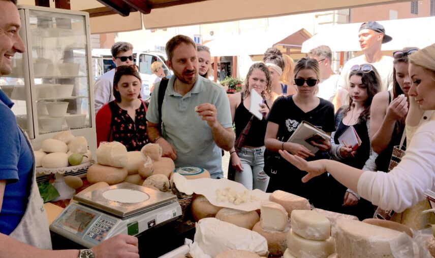 Michael A. Di Giovine with group of students at market stall with cheeses in Perugia