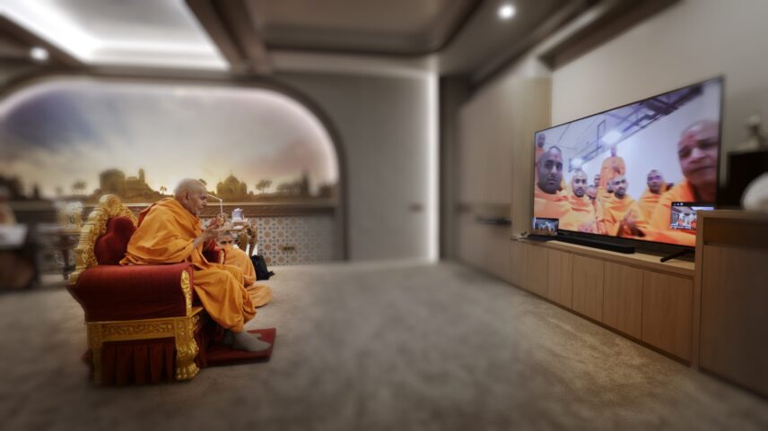 Mahant Swami Maharaj praying via video call with swamis in Abu Dhabi.