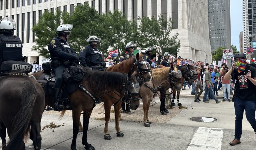 Photograph of mounted patrol officers overseeing a protest.