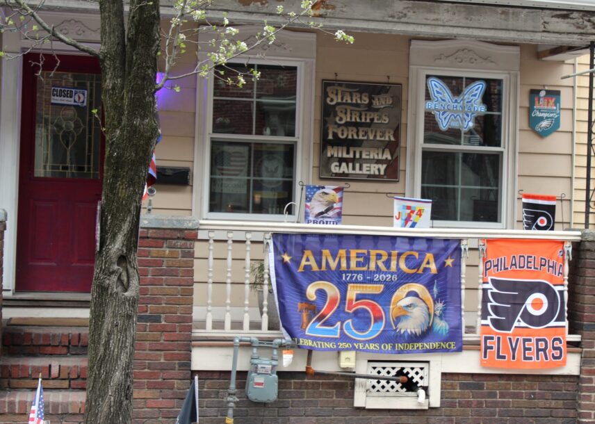 A front porch hung with USA250 alongside military and Pennsylvania sports banners